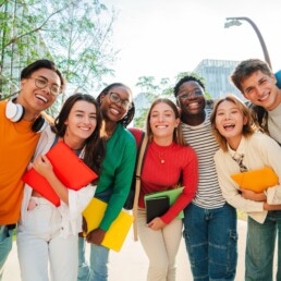 Grande grupo de estudantes sorrindo na escola, multirraciais e felizes