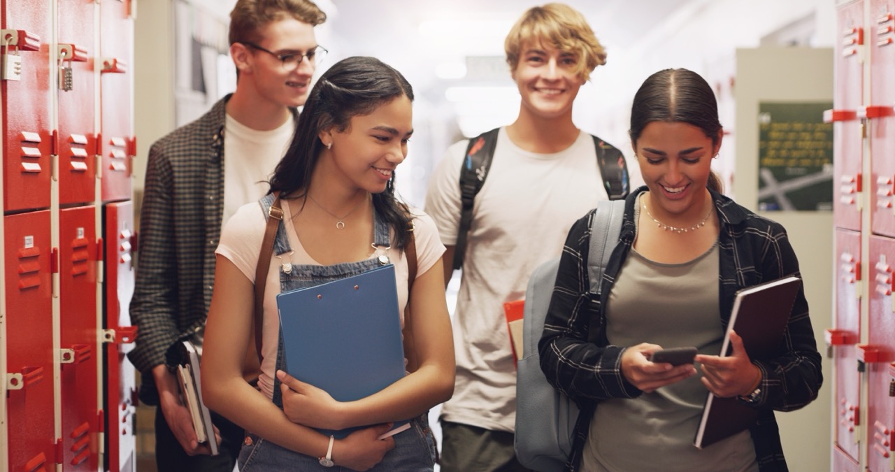 Grupo de estudantes e amigos do ensino médio no corredor do campus educacional