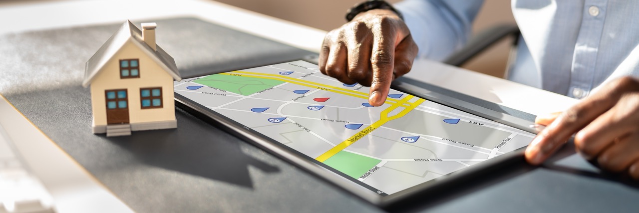 Pessoa utilizando um tablet para fazer pesquisa de localização de imóveis.