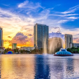 Pôr do sol e nuvens sobre o horizonte de Orlando com vista para a fonte no Lake Eola Park, Orlando, Flórida.