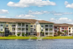 Prédios de apartamentos de três andares com uma fonte d'água no lago, localizados em Orlando, Flórida