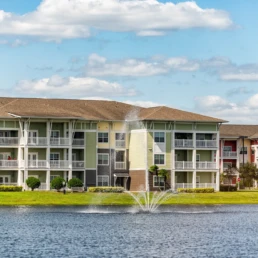 Prédios de apartamentos de três andares com uma fonte d'água no lago, localizados em Orlando, Flórida