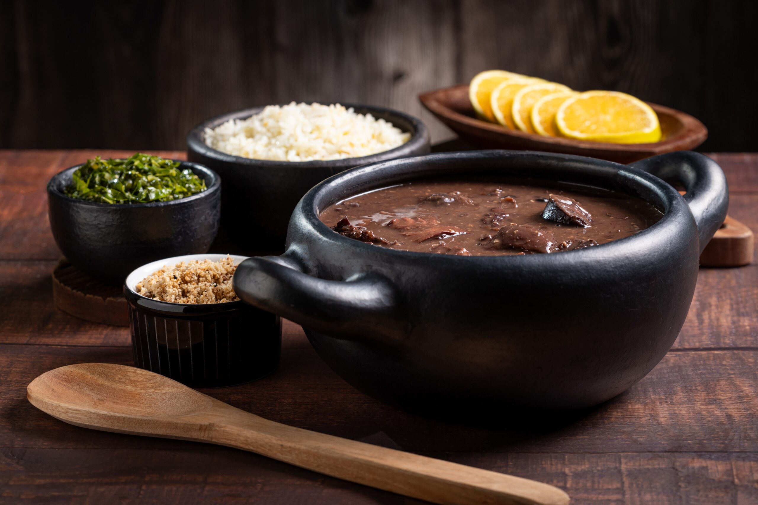 Feijoada, prato típico brasileiro feito com feijão preto, servido em uma panela de barro.