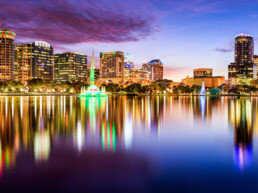 Skyline do centro de Orlando, Flórida, vista do Eola Park, com prédios altos e o lago ao fundo.