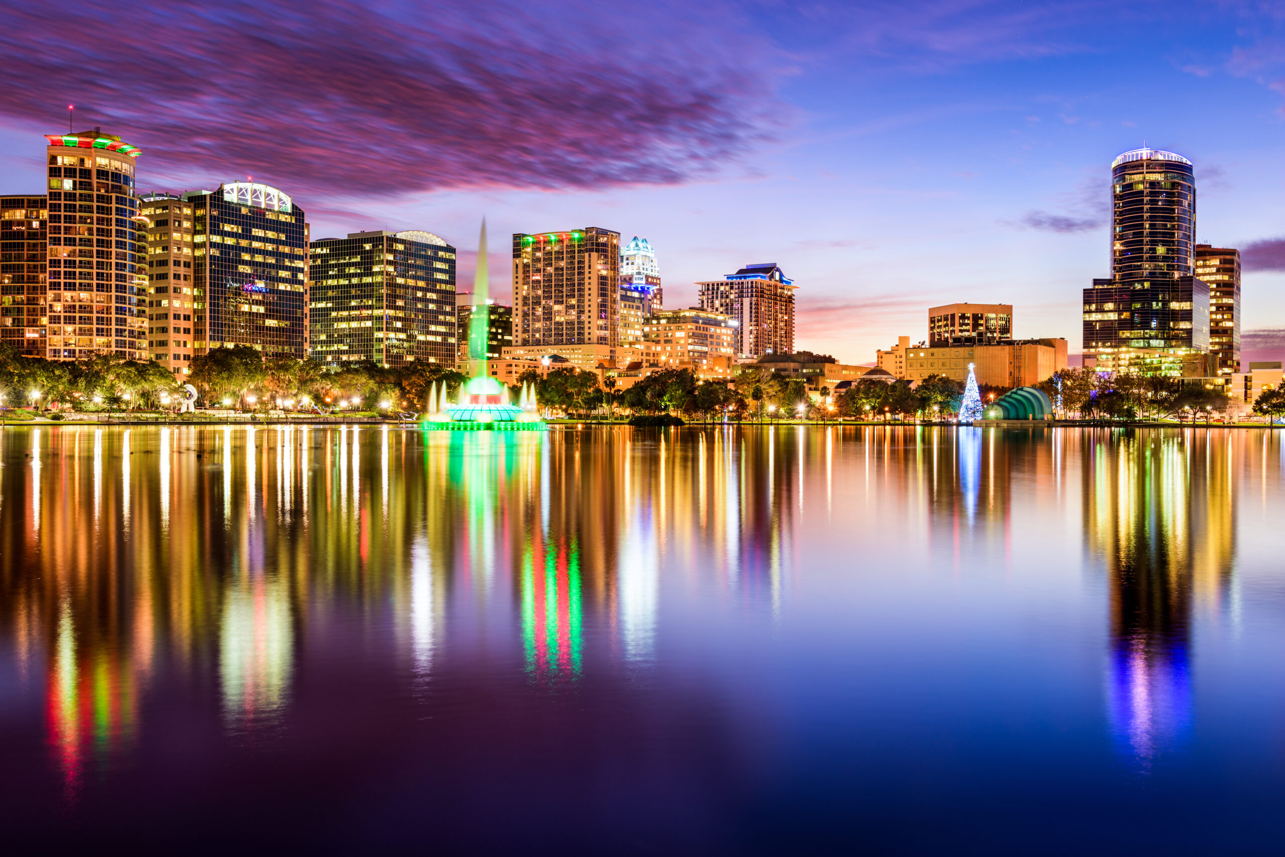 Skyline do centro de Orlando, Flórida, vista do Eola Park, com prédios altos e o lago ao fundo.